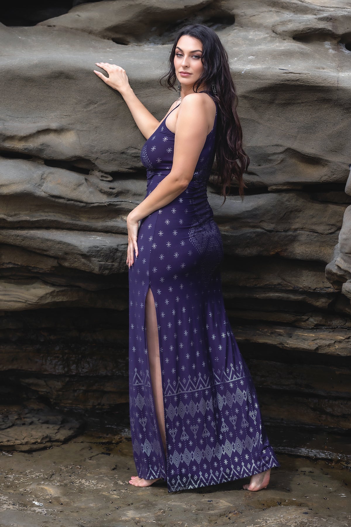 Woman posing in the desert wearing a black crop top with metallic geometric print and a high-waisted flowing black harem pant.