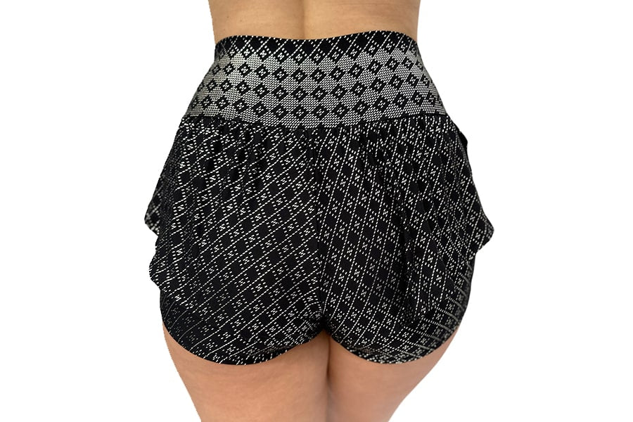 A person is shown from the back against a plain white background wearing Melodia Designs Angela Ruffle Short in a high-waisted black and white pattern.