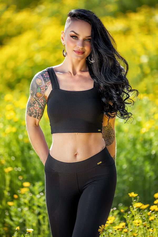 Woman wearing the Neisha Bra. The bra is black, offering a sleek look, and is made from bamboo fabric, providing both comfort and durability by Melodia Designs
