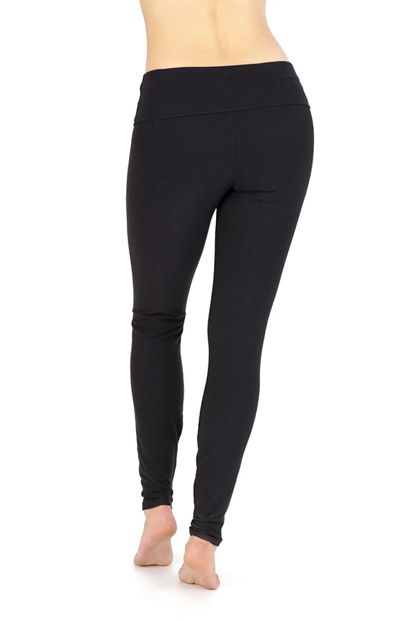 A person standing barefoot, shown from the waist down and from behind, wears Melodia Designs Elsa Pocket Legging—black, full-length leggings with a high-rise foldable waistband—against a white background.