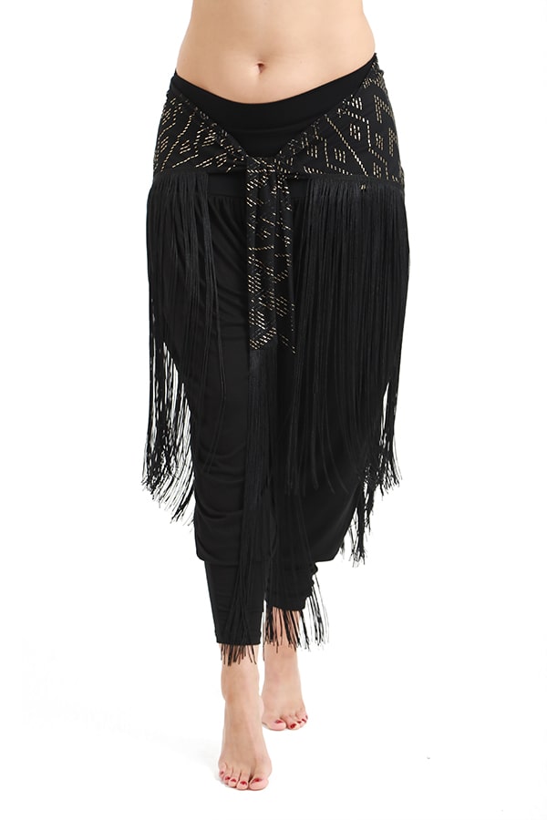 A person wearing black harem pants with Melodia Designs’ Fringe Shimmy Shawl Luxor—adorned with long, silky chainette fringe and gold patterns—stands barefoot against a white background, showcasing this statement piece.