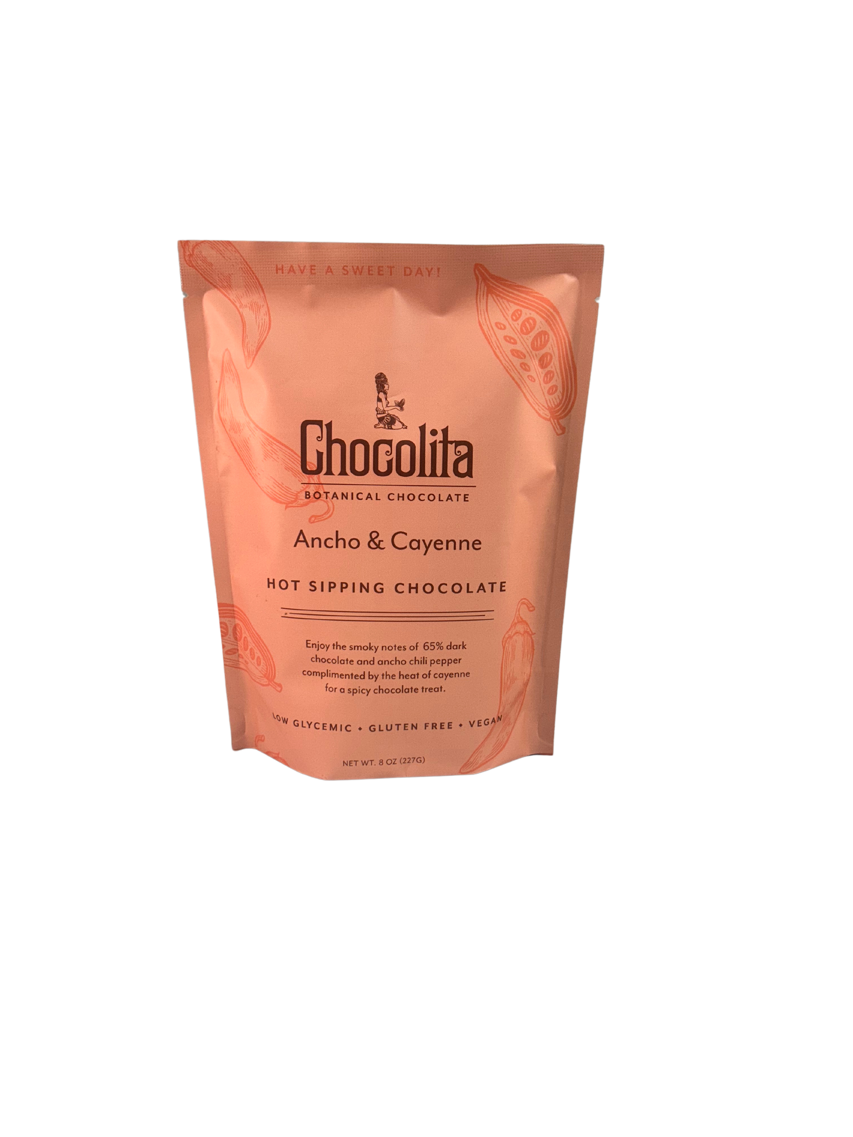 A pink, resealable bag of chocolita.com Ancho & Cayenne Sipping Chocolate features cacao pod art and text noting 65% dark chocolate, low glycemic, gluten free, vegan—Mayan-inspired botanical recipe.