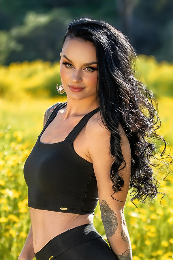 This image features a woman wearing the Neisha Bra, designed for both sports and everyday activities. The bra is black, offering a sleek look, and is made from bamboo fabric, providing both comfort and durability by Melodia Designs